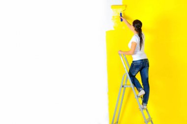 Kız ressam bir merdiven üzerinde bir panel duran bir duvar boyaları