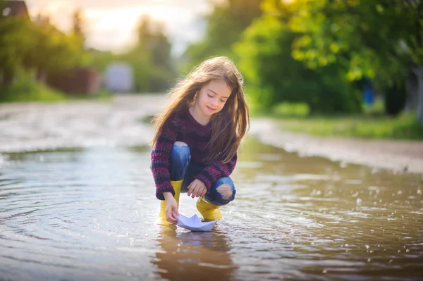 穿着黄色肥皂衣的女孩在小船的水坑里玩耍 孩子们的乐趣 — 图库照片