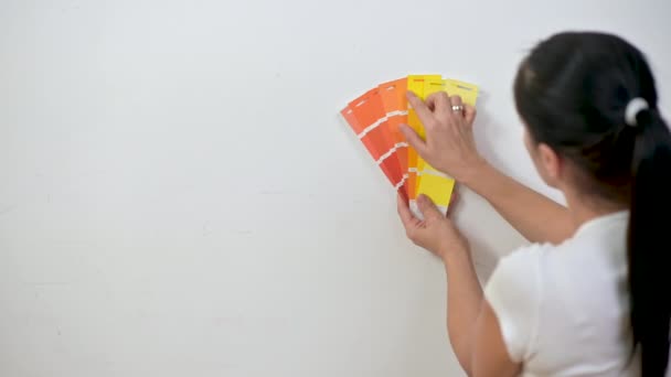 Γυναίκα Σχεδιαστής Στέκεται Κοντά Στον Τοίχο Επιλέγει Ένα Χρώμα Για — Αρχείο Βίντεο