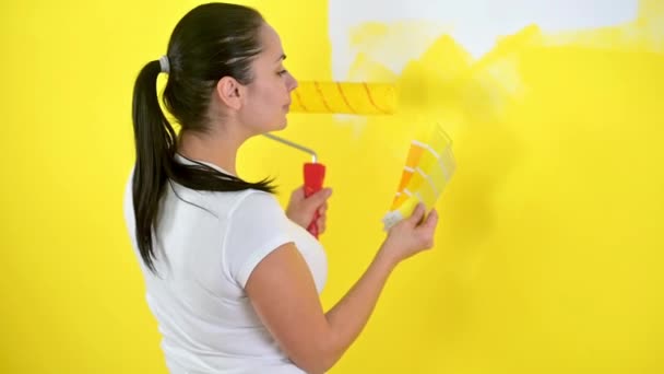 Girl painter picks a color for painting the wall. Repair in the house. — Stock Footage Girl Painter Picks Color Painting Wall Repair House Stock Footage