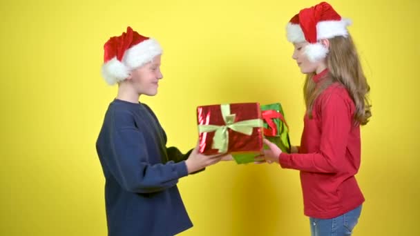 Lindos Niños Sombreros Santa Claus Dan Regalos Uno Otro Abrazan — Vídeo de stock