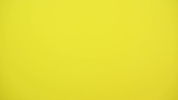 Les mains des enfants jettent vers le haut et tiennent des cadeaux sur un fond jaune studio. Des vacances. Une fête 