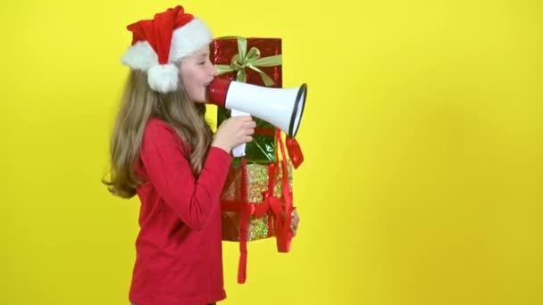 Дівчина Капелюсі Санта Клауса Коробками Руці Кричить Мегафон Жовтому Студійному — стокове відео