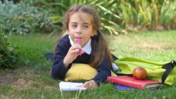 School Meisjesschoolmeisje Ligt Een Gazon Schrijft Een Notitieboekje Uhd — Stockvideo