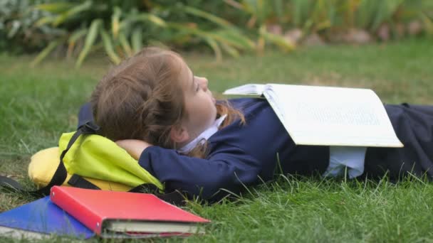 Meisje Schoolmeisje Ligt Rust Het Gazon Met Een Open Boek — Stockvideo