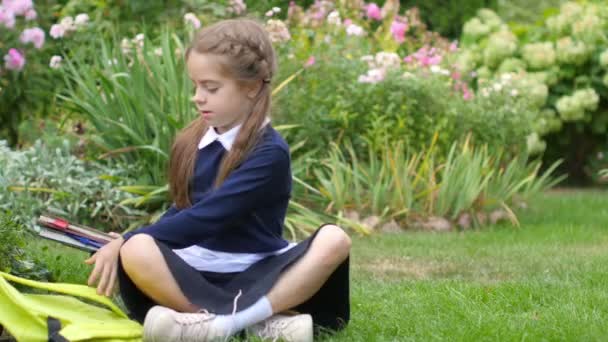 Μια Μαθήτρια Κάθεται Στο Γρασίδι Ένα Πάρκο Διπλώνει Βιβλία Ένα — Αρχείο Βίντεο