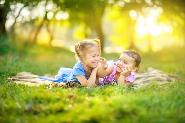 Sevimli Çocuklar Gün Batımında Parkta Oynarlar Kızlar Çimlere Uzanıp Oyun - Stok İmaj