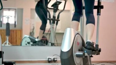 Güzel kız Orbitrek beden eğitimi konseptini yönetiyor. Fitness ve sağlıklı yaşam tarzı konsepti. Sporcu kadın fitness merkezinde çalıştırma makinesi kullanıyor.