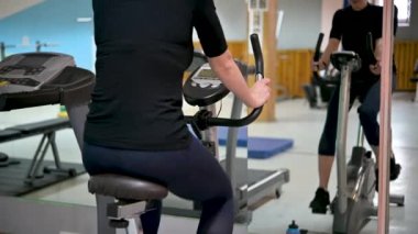 Spor salonunda egzersiz bisikleti süren genç bir sporcu kız. Sağlık hizmetleri. Spor konsepti.