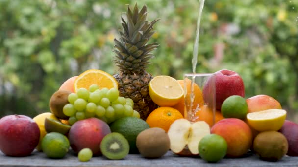 Nahaufnahme Gelber Fruchtsaft Wird Ein Glas Gegossen Verschiedene Obstsorten Auf — Stockvideo