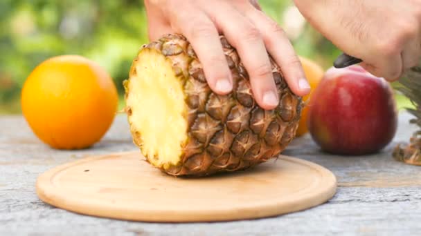 Eine Männliche Hand Schneidet Eine Reife Ananas Auf Einem Holztisch — Stockvideo