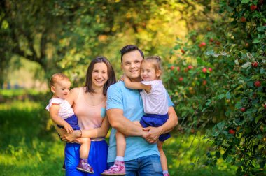 Mutlu bir aile. Bir aile güzel bir elma bahçesinde yürür, aile zamanı..