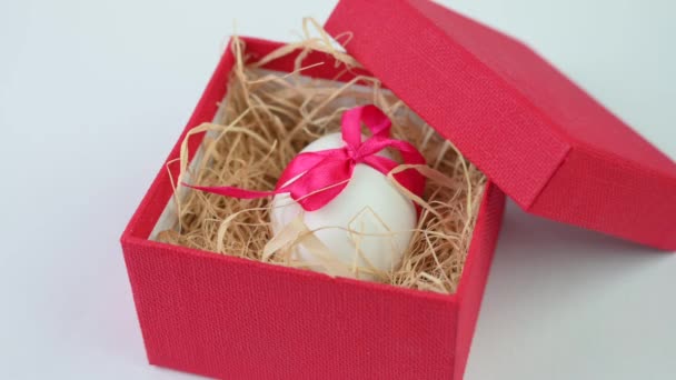 Λευκό Πασχαλινό Αυγό Διακοσμημένο Κόκκινη Κορδέλα Βρίσκεται Ένα Μικρό Κουτί — Αρχείο Βίντεο