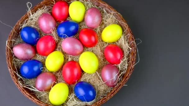 俯瞰全景的色彩斑斓的彩蛋躺在灰色背景的篮子里的培根上 复活节装饰 复活节概念背景 — 图库视频影像