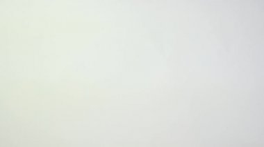 Yakından bir kadın elini tutuyor ve beyaz arka planda bir yumurta gösteriyor. Paskalya süsleri. Paskalya konsepti arka planı.