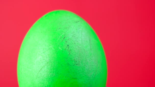 色彩艳丽的绿色复活节彩蛋在红色的背景上旋转 360轮转 复活节装饰 复活节概念背景 — 图库视频影像