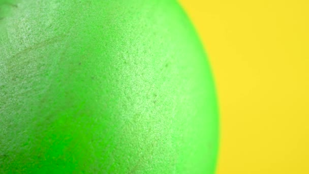カラフルな緑のイースターエッグが黄色の背景で回転します 360回転 イースターの飾り イースターのコンセプトの背景 — ストック動画
