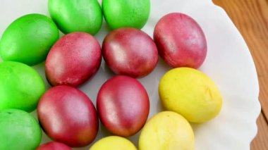 Yakından bakınca renkli paskalya yumurtaları tabakta duruyor. 360 derece dönüş. Paskalya süsleri. Paskalya konsepti arka planı.