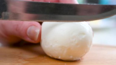 Dişi bir aşçı, haşlanmış tavuk yumurtası parçalarına bıçak çeker. Yemek pişirmek..