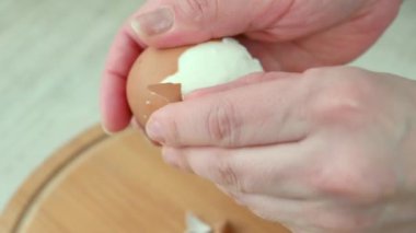 Kadın eli, haşlanmış tavuk yumurtası alır. Yemek pişirmek..
