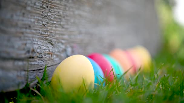 Childrens hand takes a colorful easter egg on the lawn. Easter Egg Hunt In Garden Easter concept background.