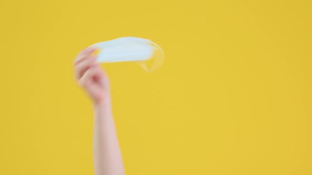 Vrouwelijke Handen Met Een Medisch Gezichtsmasker Zwaaiend Een Geïsoleerde Gele — Stockvideo