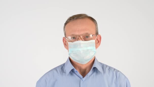 Oudere Man Met Een Bril Een Medisch Masker Geïsoleerd Een — Stockvideo