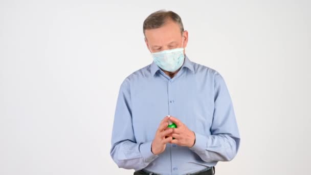 Anciano Con Una Máscara Médica Trata Sus Manos Con Aerosol — Vídeo de stock