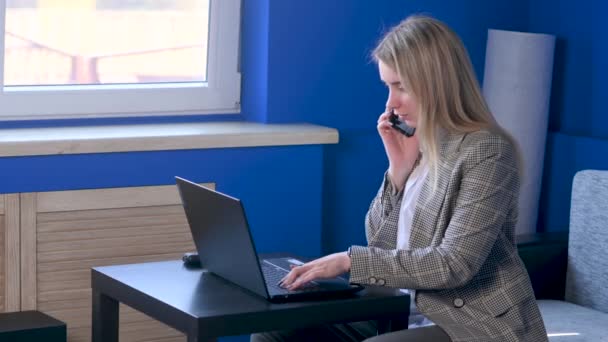 Genç Kadını Telefonda Dizüstü Bilgisayarla Konuşuyor Ofis Masasında Oturuyor Serbest — Stok video