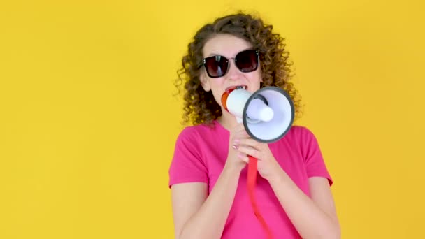 Gadis Muda Berkacamata Berbicara Megafon Mengumumkan Berita Dengan Latar Belakang — Stok Video