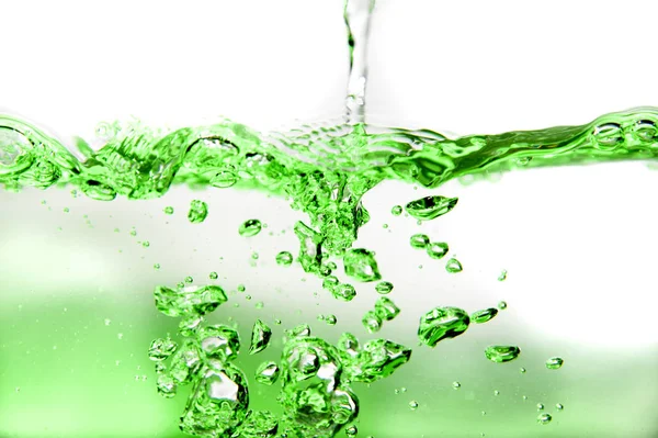 Green lit water splash with bubbles Royalty Free Stock Images