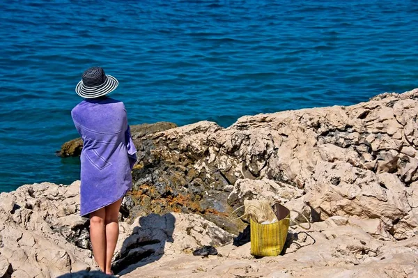 Donne in cappello e asciugamano sulla riva del mare — Foto Stock