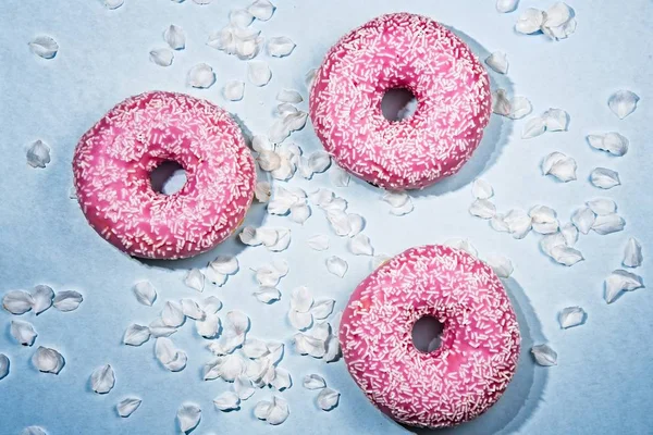 Three pink sparkled doughnouts