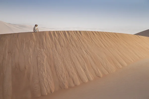 Homem em kandura num deserto ao nascer do sol — Fotografia de Stock