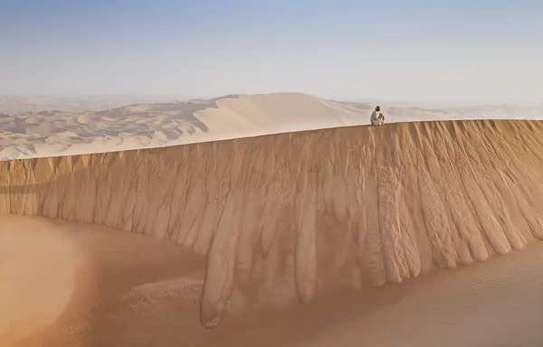 Man in kandura in a desert at sunrise — Stock Photo, Image