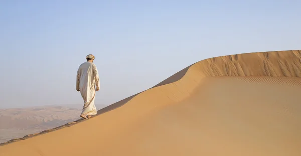 Man in kandura in a desert at sunrise — Stock Photo, Image