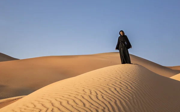 Mujer en abaya en dunas de arena — Foto de Stock