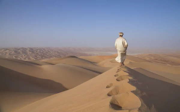 Homem em kandura num deserto ao nascer do sol — Fotografia de Stock