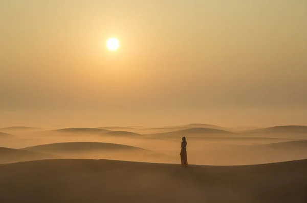 Жінка стоїть на піщаній дюні — стокове фото
