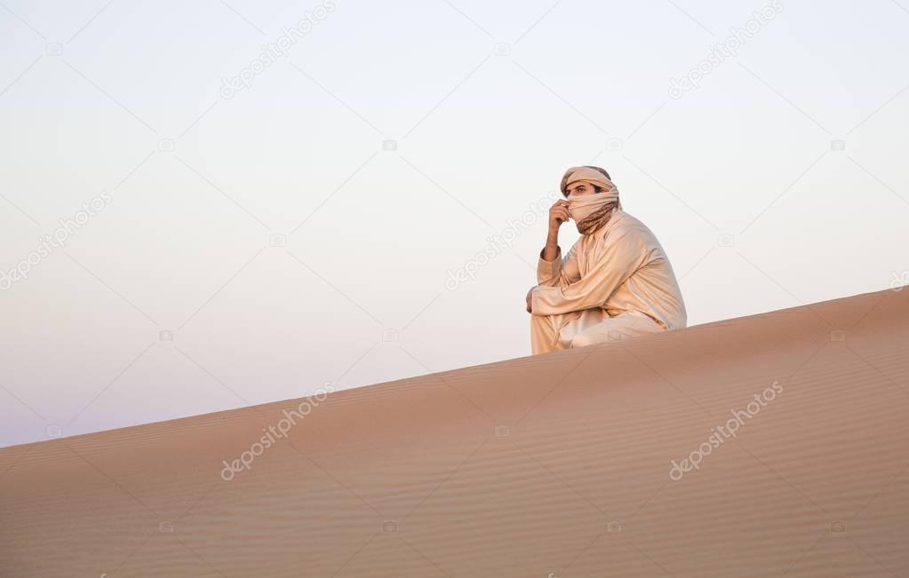man in traditional outfit in desert 