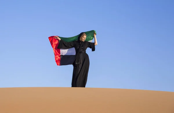 Mulher com bandeira dos Emirados Árabes Unidos no deserto — Fotografia de Stock