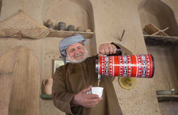 Omani man serving arabic coffee