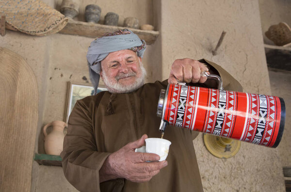 Omani man serving arabic coffee