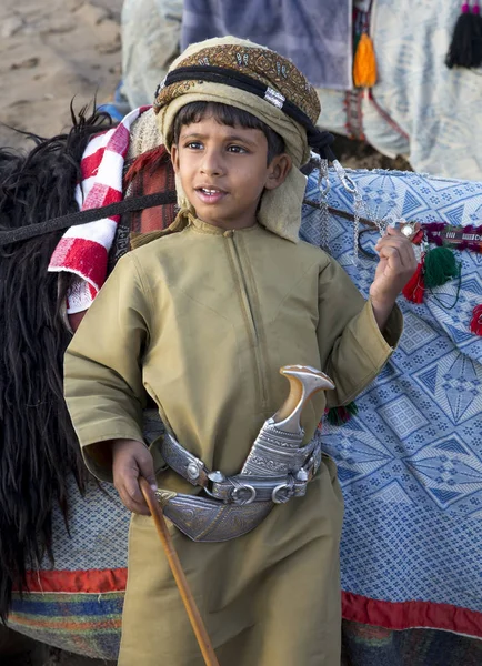 Garçon en vêtements traditionnels avec chameau — Photo