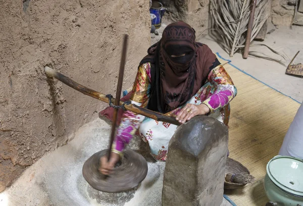 Омани женщина, молотящая пшеницу — стоковое фото