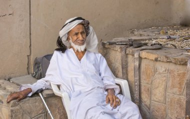 Markette oturan eski Omani adam