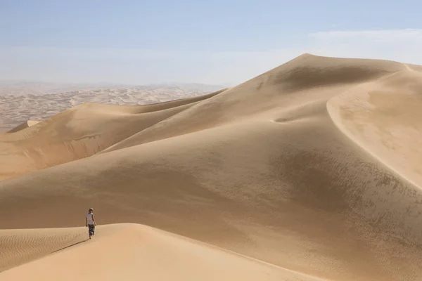 man walking in Liwa desert