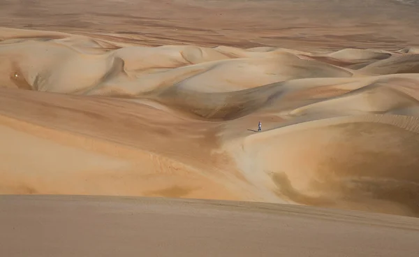 Homem andando em dunas de areia — Fotografia de Stock