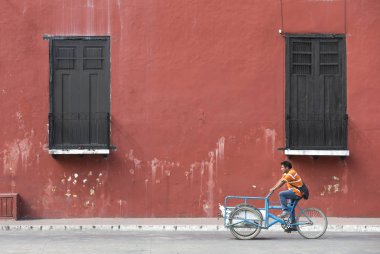 adam kırmızı duvar önünde bisikletle