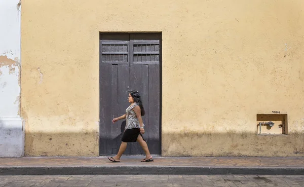 Kvinnan promenader framför gamla hus — Stockfoto
